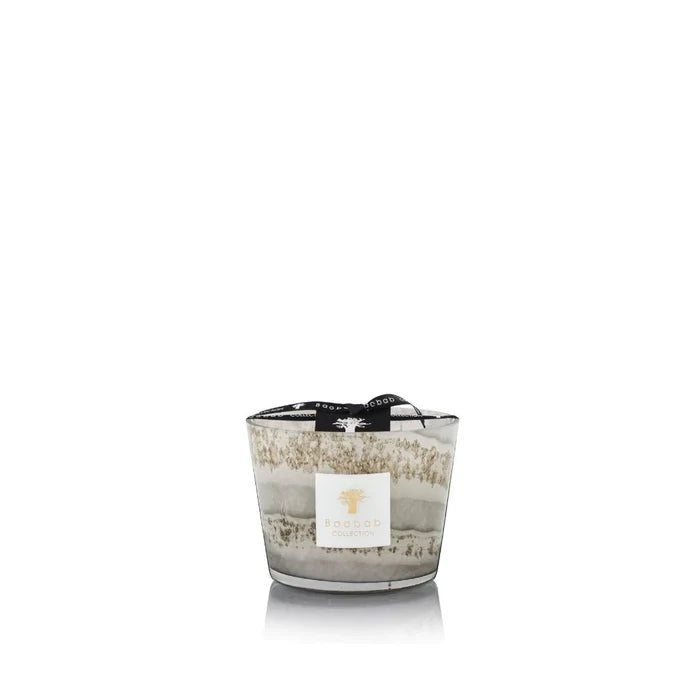 A set of hand-blown gray glass candles with various sizes, each holding a candle with a beige label.