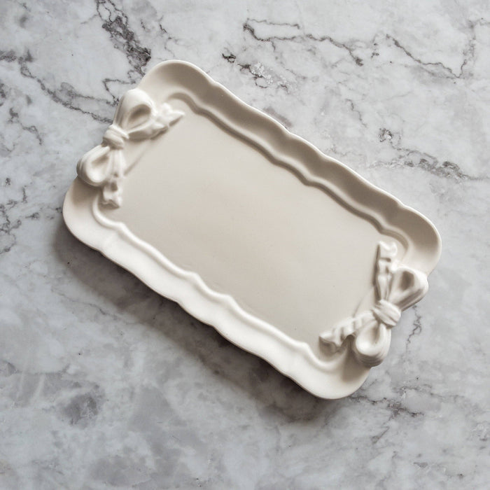 Decorative tray with bow details on a marble surface