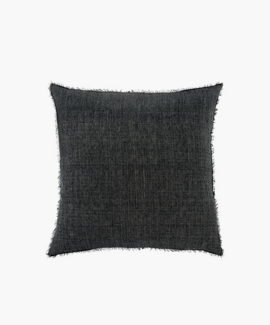 A charcoal gray square pillow with a soft texture and frayed edges. The pillow has a subtle woven pattern, creating a cozy and modern aesthetic. | Wildwood Home Co.