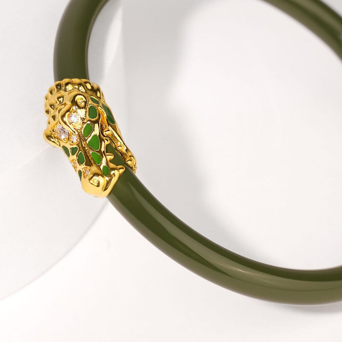 a green bracelet with a gold head