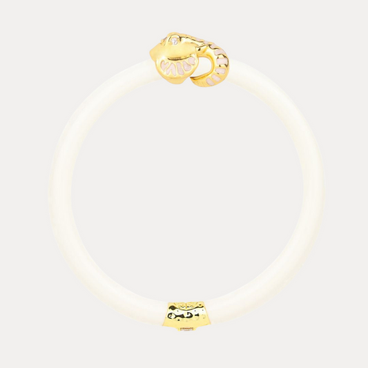 a white bracelet with a gold snake charm