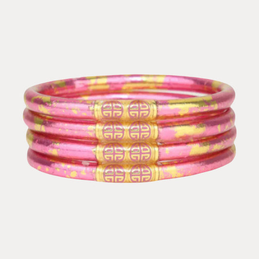 a stack of pink and gold bracelets