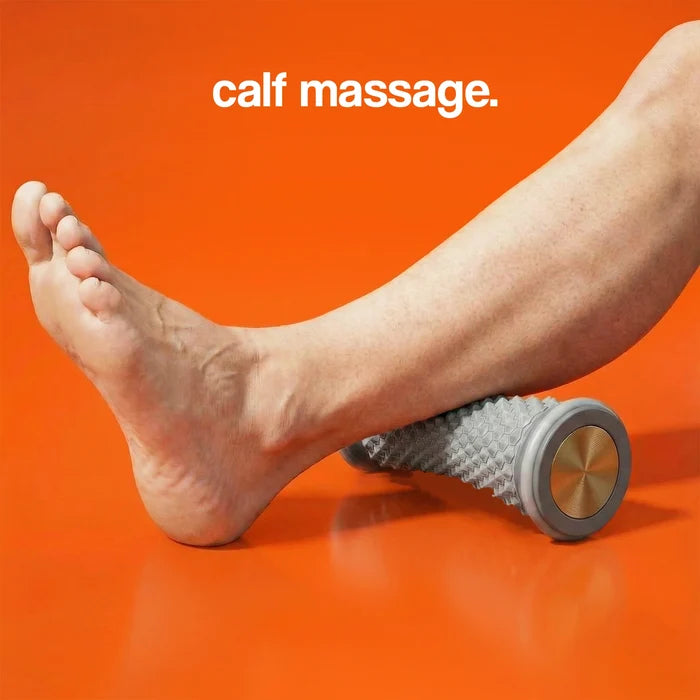 Calf massage roller on an orange background with a foot resting on the textured gray surface.