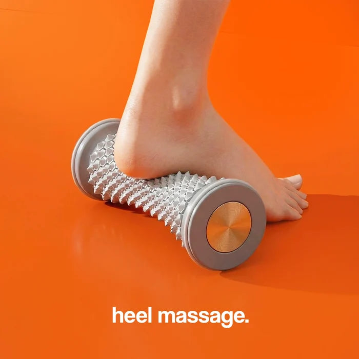 Massage roller with a textured surface, positioned under a foot on an orange background.